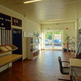Eingangsbereich mit Sitzecke, Einheitentafel, Infomaterial und Playmobilvitrine